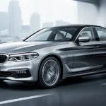 Srebrny sedan BMW serii 5 G30 ustawiony przodem w ujęciu trzy czwarte na tle nowoczesnego miejskiego krajobrazu.