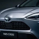 Toyota Yaris Cross – zbliżenie na przód auta: grill i reflektory w profesjonalnym, chłodnym oświetleniu studyjnym