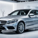 Srebrny sedan Mercedes Klasy C W206 zaparkowany w nowoczesnym, minimalistycznym salonie samochodowym.