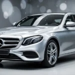Srebrny sedan Mercedes klasy E W213 w nowoczesnym salonie, ujęcie z przodu na tle rozmytego wnętrza.