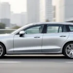 Srebrne Volvo V60 II widziane z profilu na nowoczesnej drodze w miejskiej scenerii w świetle dziennym.