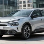 Srebrny Citroen C4 III zaparkowany na tle nowoczesnych przeszklonych budynków w słoneczny dzień.