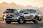Srebrna Honda CR-V V zaparkowana na asfaltowej drodze w otoczeniu górskiego krajobrazu podczas złotej godziny.