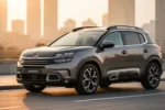Elegancki Citroen C5 Aircross zaparkowany na nowoczesnej drodze w ciepłym świetle zachodzącego słońca.