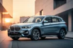 Nowoczesny SUV BMW X1 U11 zaparkowany na minimalistycznej miejskiej ulicy w świetle zachodzącego słońca.