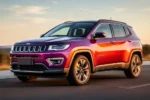 Elegancki SUV Jeep Compass na asfaltowej drodze w świetle złotej godziny, widok z przodu pod kątem.
