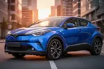 Nowoczesna Toyota C-HR o ostrych liniach nadwozia zaparkowana na miejskiej ulicy w świetle zachodzącego słońca.